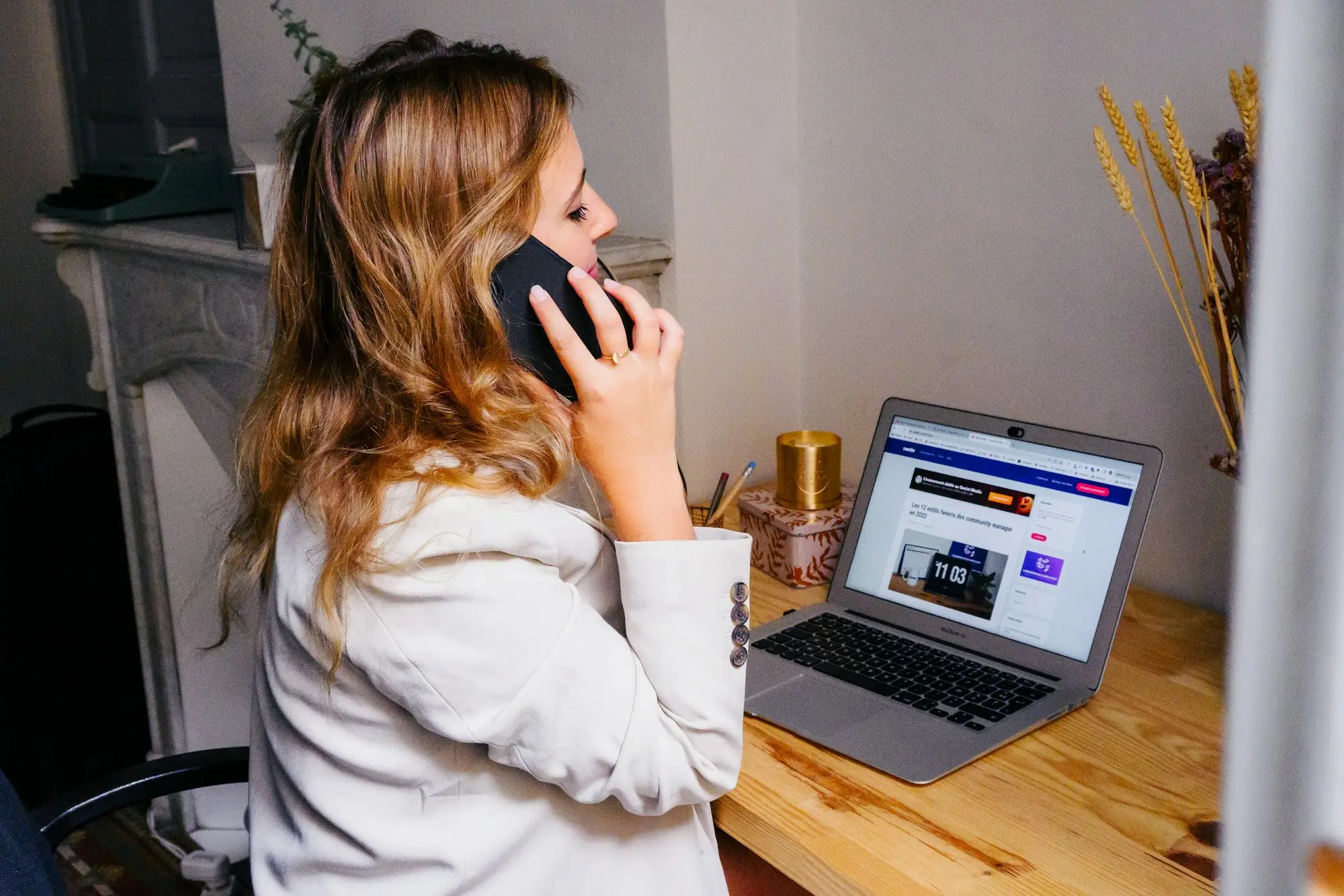 Business owner talking on the phone at a desk with an open laptop